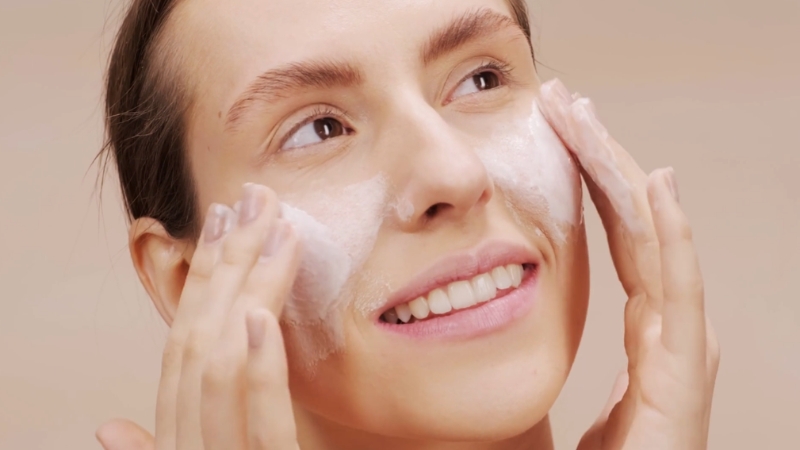 Žena čisti lice penastom umivalicom